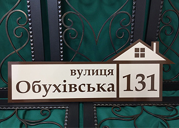 Адресна табличка на фасад з формою будинку