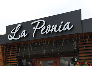 Літери на композитному коробі "La Peonia" на фасаді будівлі