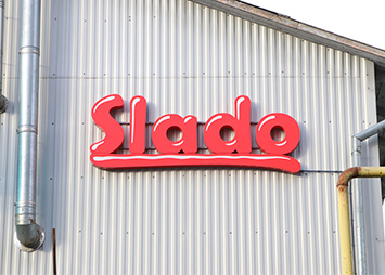 Объемные буквы красного цвета "Slado" на фасаде здания
