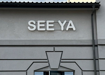 Объемные световые буквы "SEE YA" на каркасе с креплением на фасаде здания